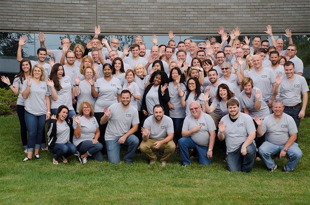 C2G employees smiling and waving for a photo.